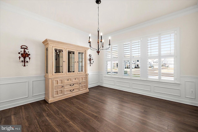 unfurnished dining area featuring ornamental molding, dark wood-type flooring, and a notable chandelier