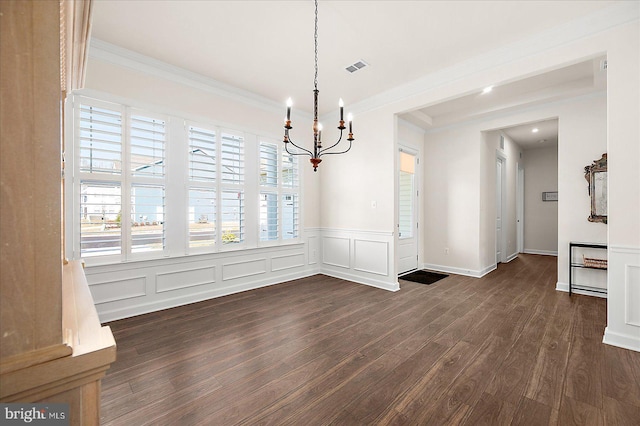 unfurnished dining area featuring ornamental molding, dark hardwood / wood-style floors, and a chandelier