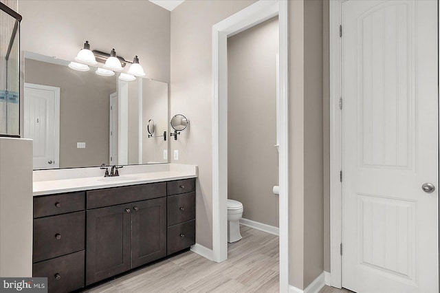 bathroom featuring vanity, hardwood / wood-style floors, and toilet