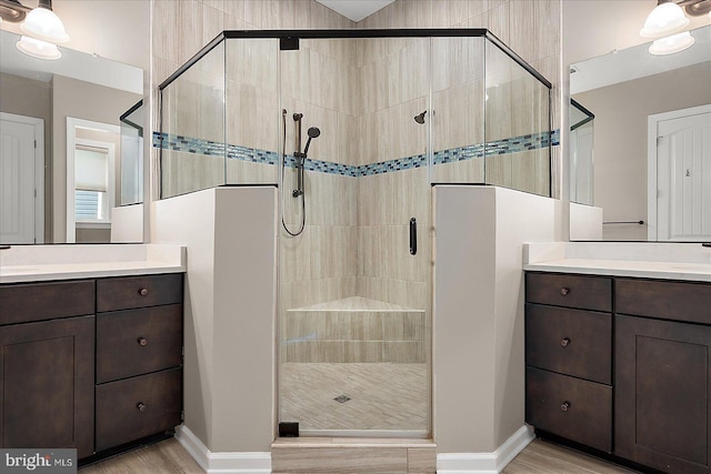 bathroom with hardwood / wood-style flooring, vanity, and a shower with shower door