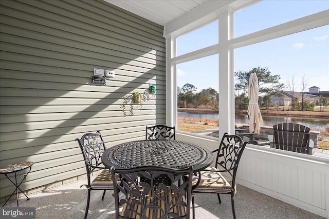 sunroom / solarium featuring a water view