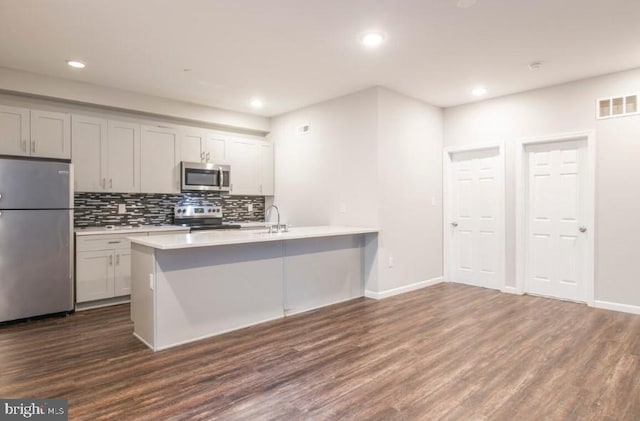 kitchen with gray cabinetry, sink, stainless steel appliances, dark hardwood / wood-style floors, and backsplash