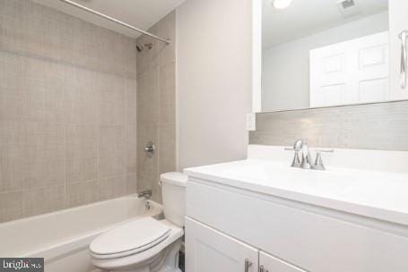 full bathroom featuring toilet, vanity, and tiled shower / bath