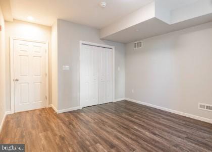 unfurnished bedroom with dark hardwood / wood-style flooring and a closet