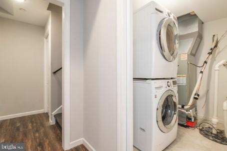 washroom featuring stacked washer and dryer and dark hardwood / wood-style floors