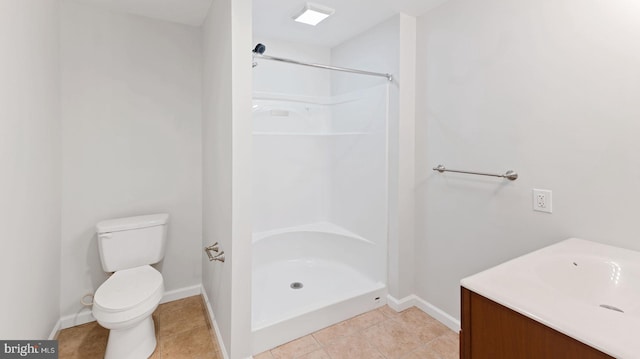 bathroom with tile patterned floors, vanity, toilet, and a shower