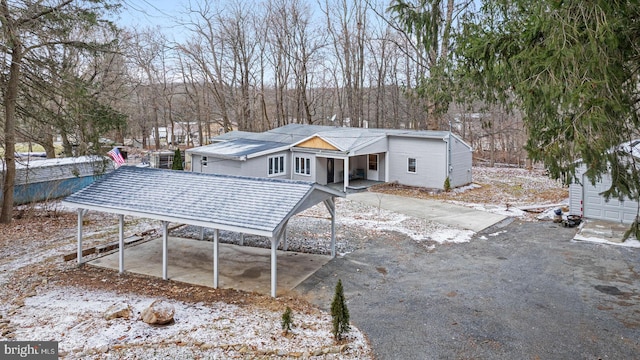 snow covered house featuring a carport