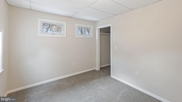 spare room featuring carpet floors and a paneled ceiling