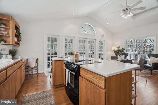 kitchen featuring electric range, vaulted ceiling, a kitchen breakfast bar, and a kitchen island