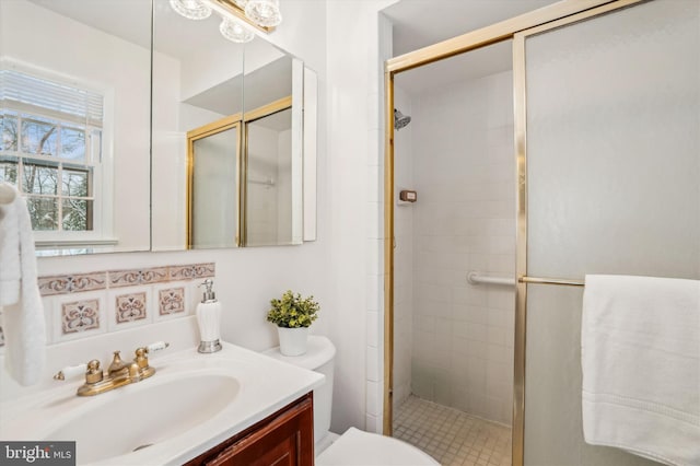 bathroom with an enclosed shower, vanity, and toilet