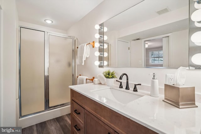 bathroom featuring vanity, wood-type flooring, and walk in shower