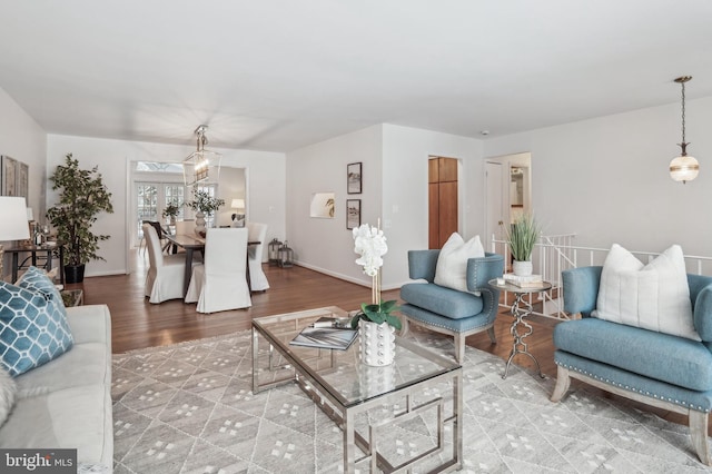 living room featuring wood-type flooring and a chandelier