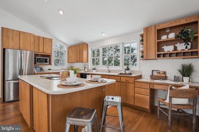 kitchen with lofted ceiling, stainless steel appliances, dark hardwood / wood-style floors, a center island, and a kitchen breakfast bar