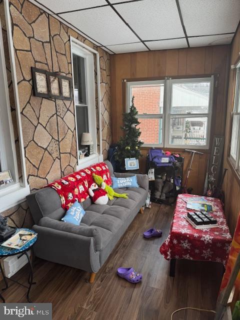 living room with a paneled ceiling and wood-type flooring