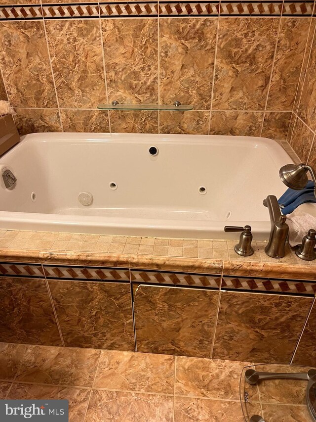 bathroom with tile patterned floors and tiled tub