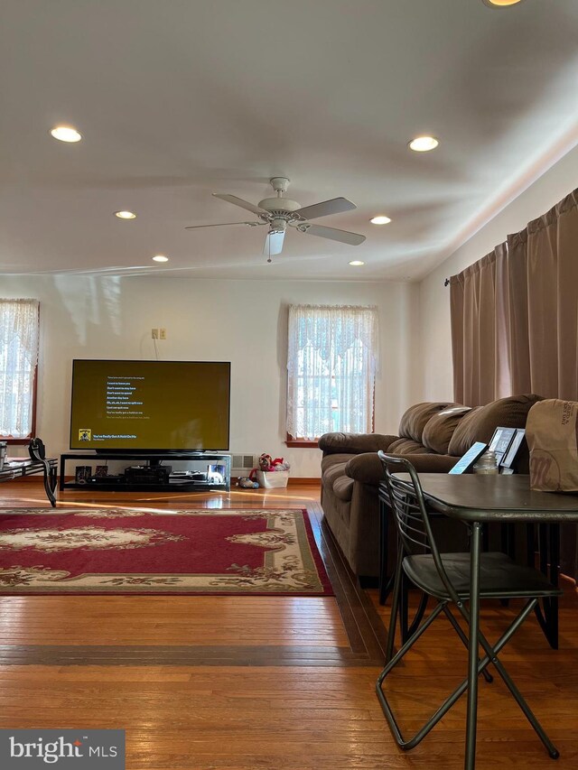 living room featuring hardwood / wood-style floors and ceiling fan