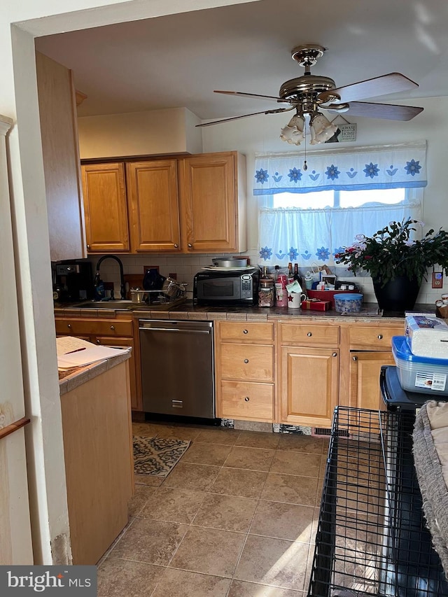 kitchen featuring dishwasher, backsplash, ceiling fan, and sink