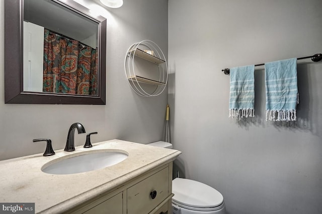 bathroom featuring toilet and vanity