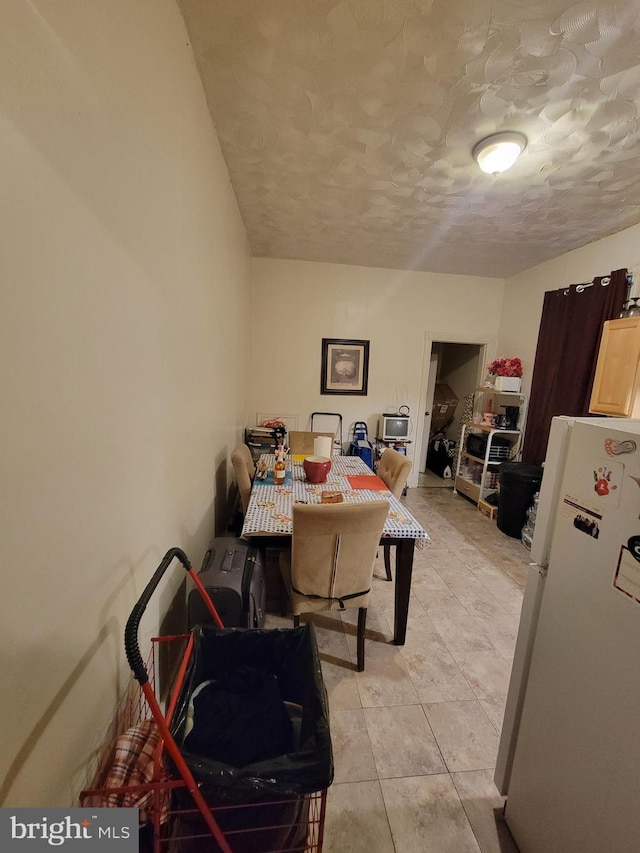 tiled dining space with a textured ceiling