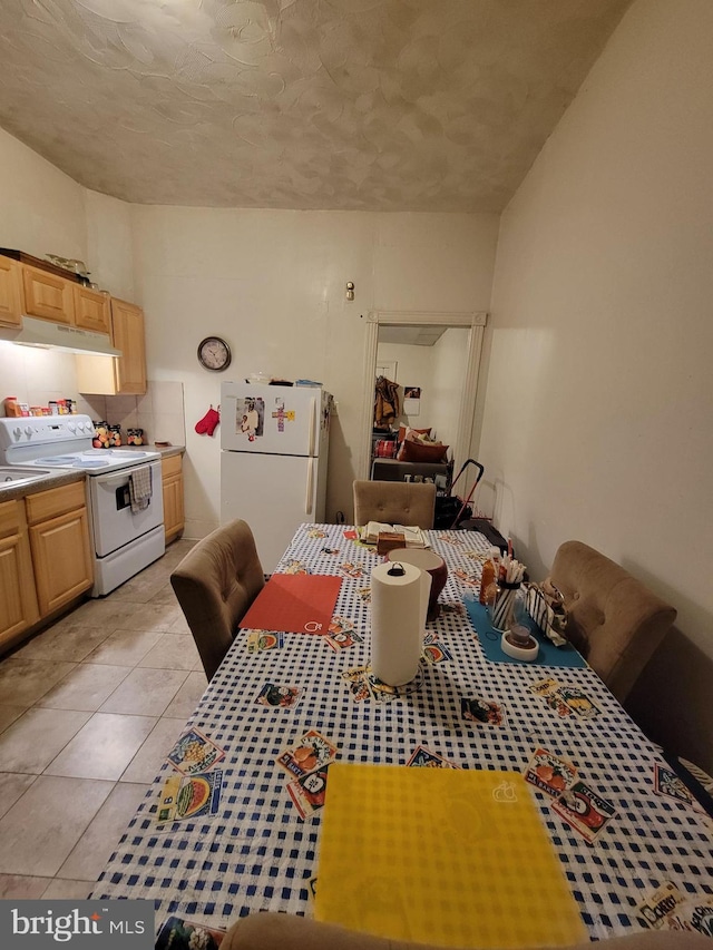 tiled dining room featuring a textured ceiling