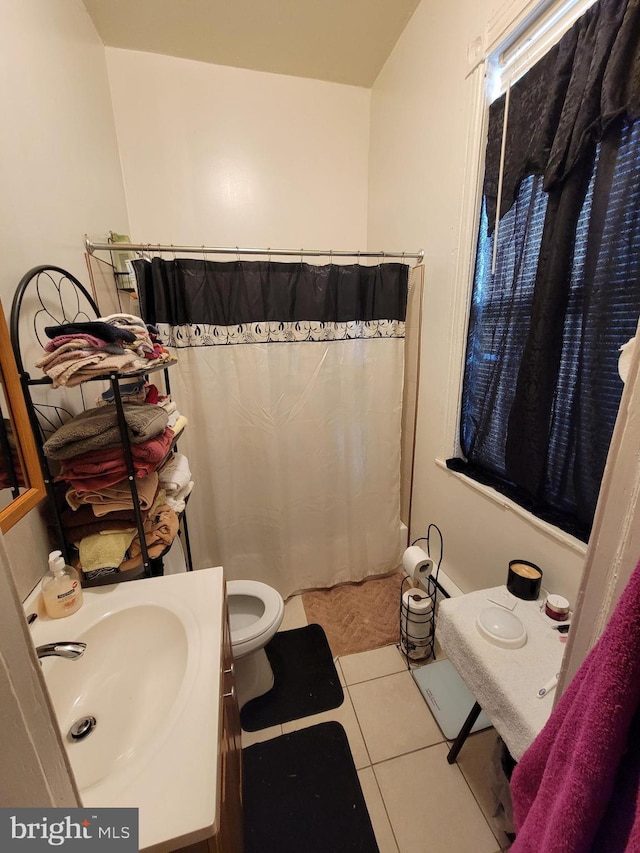 bathroom featuring toilet, tile patterned floors, and sink