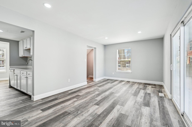 unfurnished living room with light wood-type flooring and sink