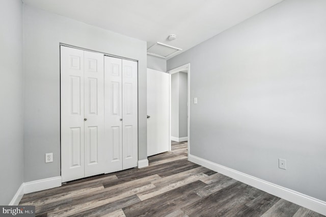 unfurnished bedroom featuring dark hardwood / wood-style flooring and a closet