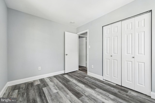 unfurnished bedroom featuring dark hardwood / wood-style floors and a closet