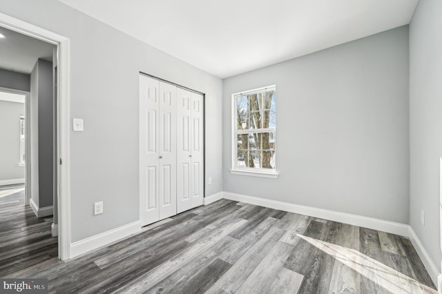 unfurnished bedroom featuring dark hardwood / wood-style flooring and a closet