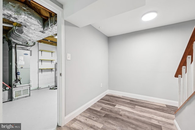 basement with heating unit and light wood-type flooring