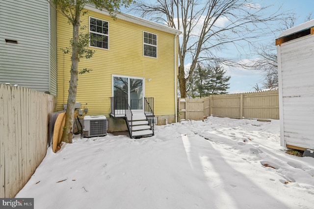 snow covered rear of property with central AC unit