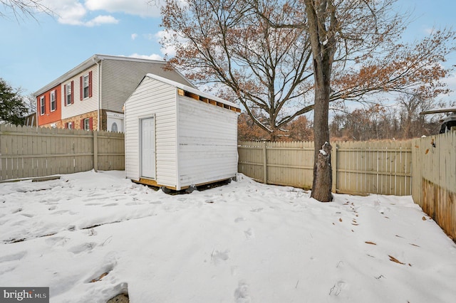 yard covered in snow with a storage shed