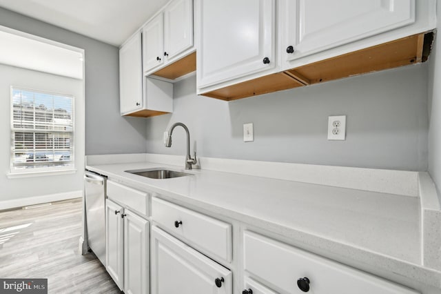 kitchen featuring white cabinetry, sink, dishwasher, and light hardwood / wood-style floors