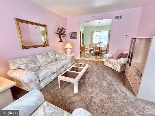 carpeted living room with a chandelier