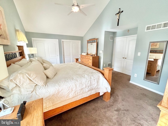 bedroom with high vaulted ceiling, two closets, dark carpet, and ceiling fan