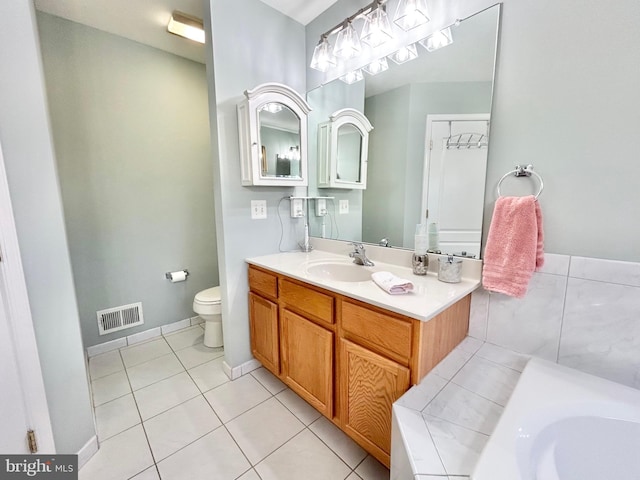 bathroom with tile patterned flooring, vanity, toilet, and a bath