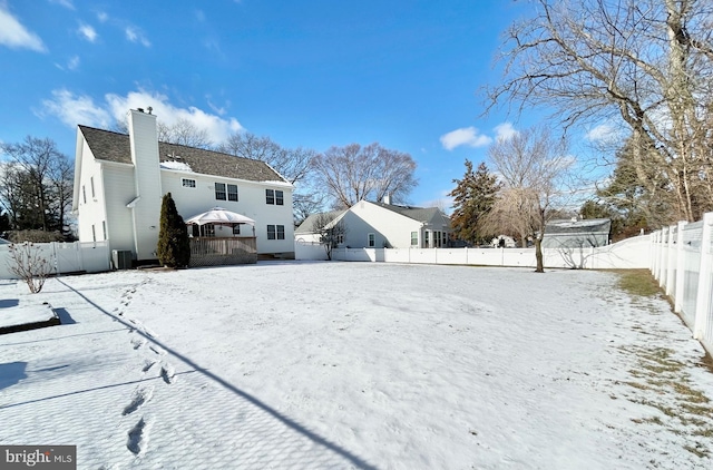 snow covered house featuring a wooden deck