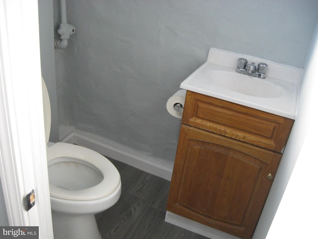 bathroom with hardwood / wood-style floors, vanity, and toilet