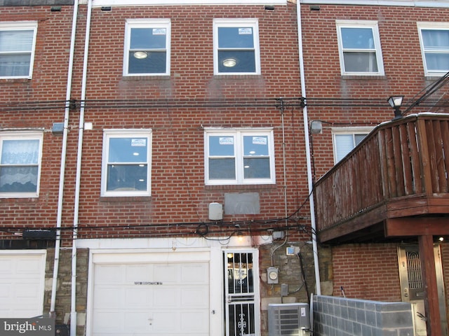 back of property with a garage and central air condition unit