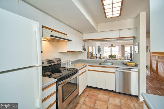 kitchen with white cabinets, sink, light tile patterned floors, and stainless steel appliances