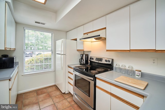 kitchen with white cabinets, white refrigerator, and electric stove