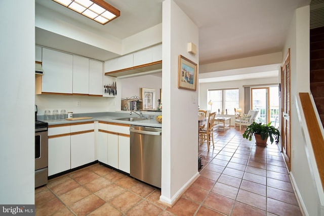 kitchen with white cabinets, sink, light tile patterned floors, and stainless steel appliances