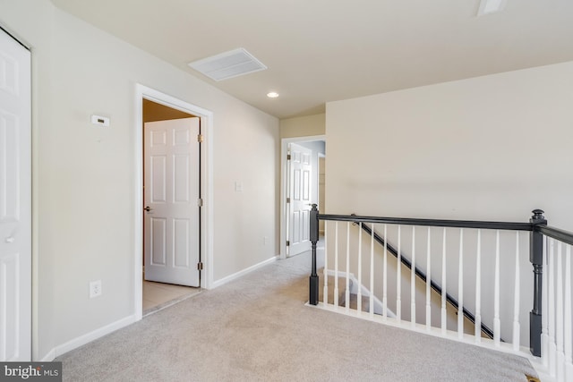 hallway featuring light colored carpet