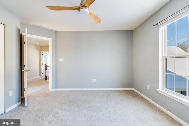 carpeted spare room with ceiling fan