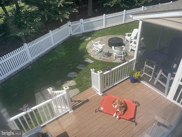 wooden deck featuring a lawn and an outdoor fire pit