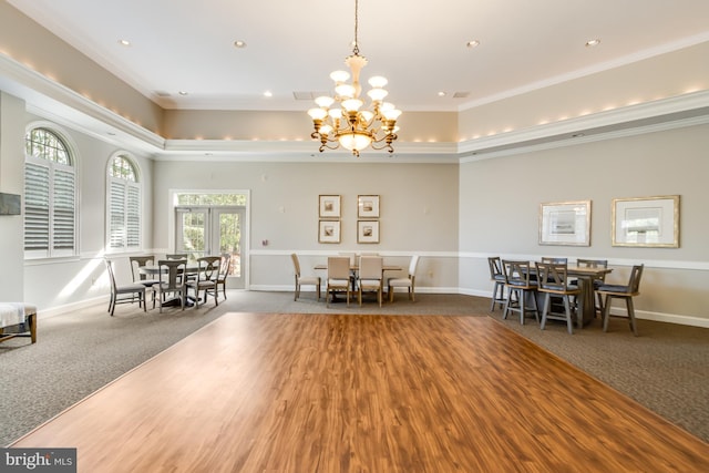 carpeted dining room featuring crown molding and a tray ceiling