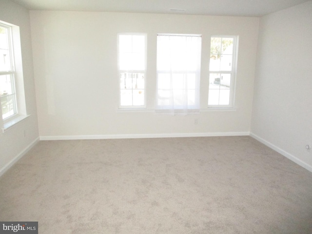 carpeted spare room featuring an inviting chandelier