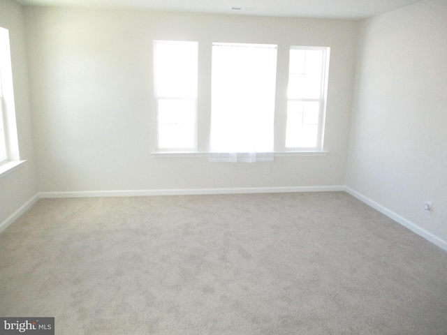 spare room with light colored carpet and a healthy amount of sunlight