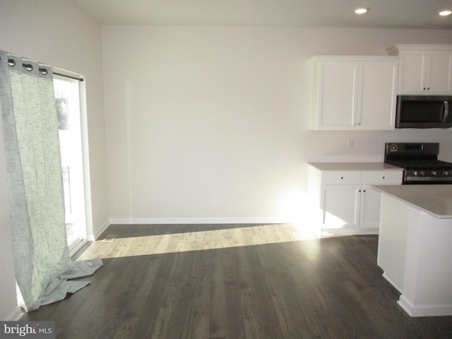 kitchen featuring dark hardwood / wood-style floors, white cabinetry, and black range with electric cooktop