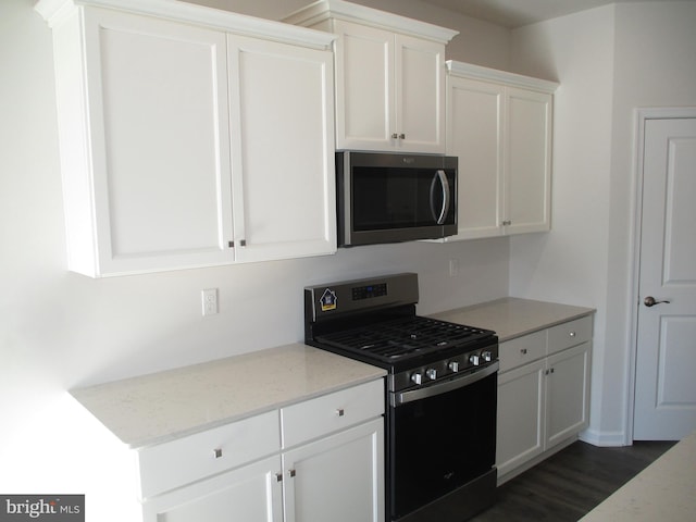 kitchen featuring white cabinets, black gas stove, dark hardwood / wood-style floors, and light stone countertops